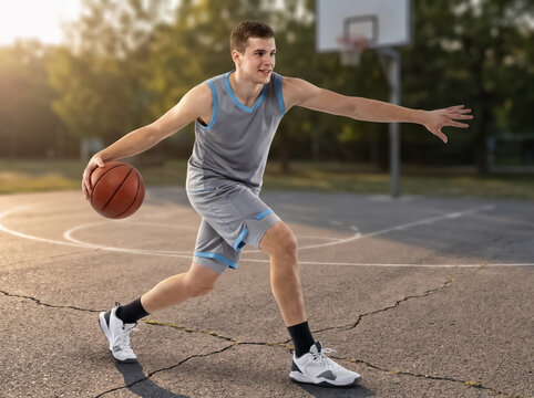Basketball player dribbling on outdoor court