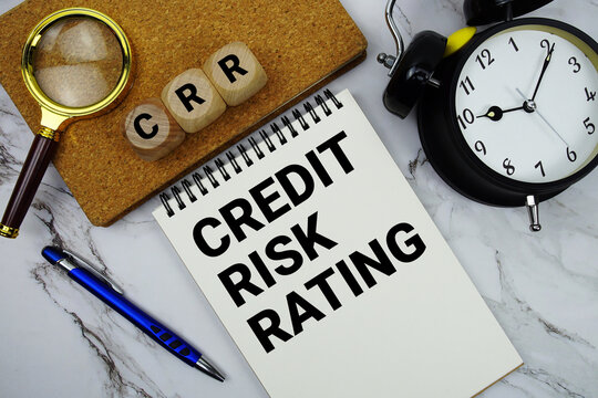 CRR Credit Risk Rating text written on notepad with magnifying glass and alarm clock on marble background