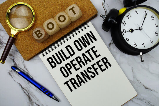 BOOT Build Own Operate Transfer text written on notepad with calculator and magnifying glass on marble background