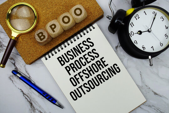 BPOO Business Process Offshore Outsourcing text written on notepad with calculator and magnifying glass on marble background