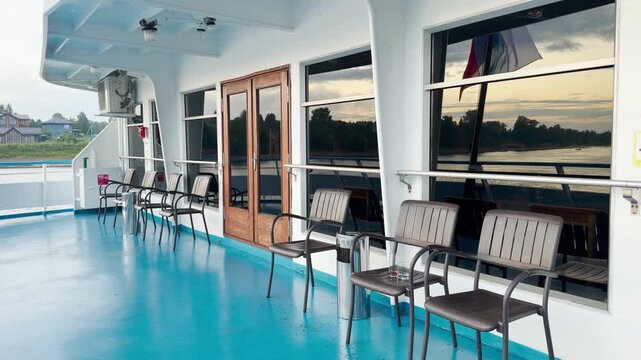 A modern cruise ship sails peacefully along the Neva River. Passengers relax on the open deck, enjoying the calm atmosphere. The serene journey brings a feeling of happy tranquility.