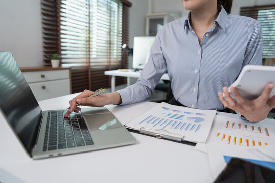 Woman analyzing reports and calculating figures at a desk