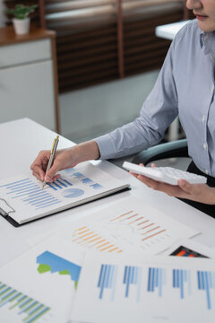 Person analyzing financial data and calculating on calculator