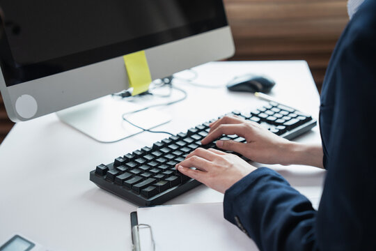 Person typing on computer keyboard at desk