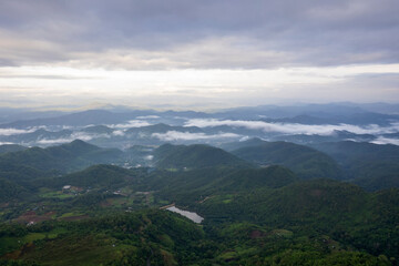 Fototapeta premium Landscape of Morning Mist with Mountain Layer. mountain ridge and clouds in rural jungle bush forest