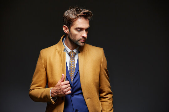 Thinking, business and man in studio with fashion, luxury outfit and designer suit for branding. Mockup space, vision and person with formal clothes, stylish attire and new release on dark background