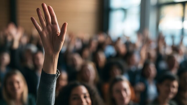 Audience Member Raising Hand During Seminar in Crowded Conference Hall Participation Question Voting Education Training Workshop Public Speaking Community Engagement and Group Discussion Concept