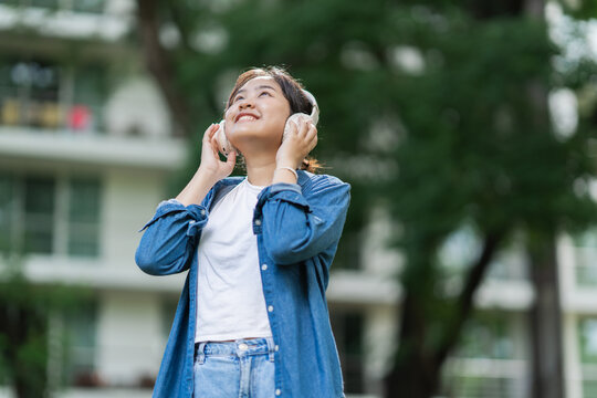 Young woman enjoying music listening with headphones outdoors