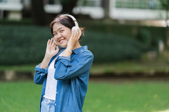 Young woman enjoying music outdoors wearing headphones