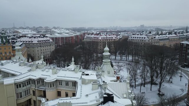 Drone Shot of Stockholm Sweden on Cold Winter Day. Flying Above Snow Capped Residential Buildings and Circular Park