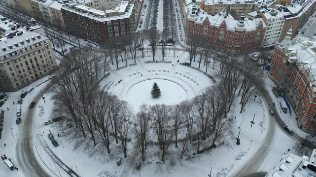 Stockholm Sweden, Drone Shot of Snow Capped Circular Park, Roundabout Traffic and Buildings on Cold Winter Day