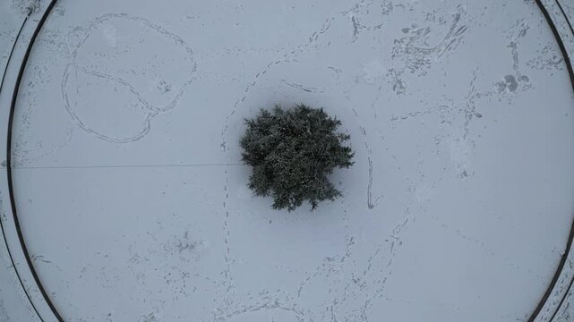 Top Down Drone Shot of Snow Capped Circular Park in Residential Neighborhood of Stockholm Sweden on Cold WInter Day