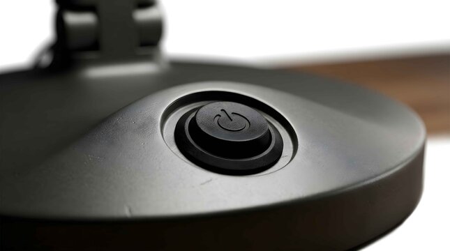 Close up view of black power button on modern desk lamp base