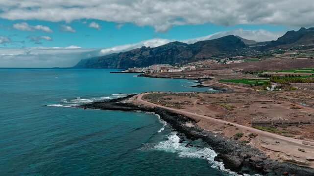 Aerial view of a coastal city and the ocean, Atlantic Ocean, Tenerife: view of the town and the Los Gigantes cliffs and Masca Mountains.