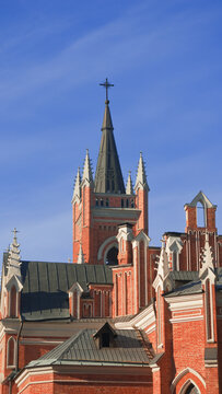Church building with spire and cross against blue sky