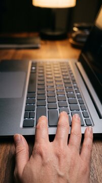 Close up of a hand hesitating over a laptop keyboard