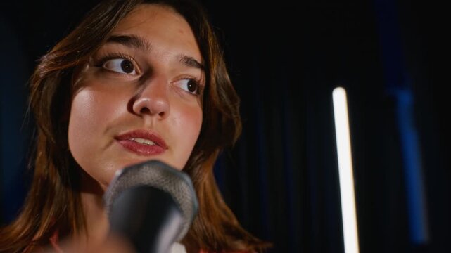 Caucasian teenager performing dramatic monologue into microphone during theater rehearsal. Footage suitable for acting workshop promos, arts education campaigns