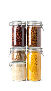 Tall vertical stack of four clear glass storage jars filled with dry food organised zero waste generative AI