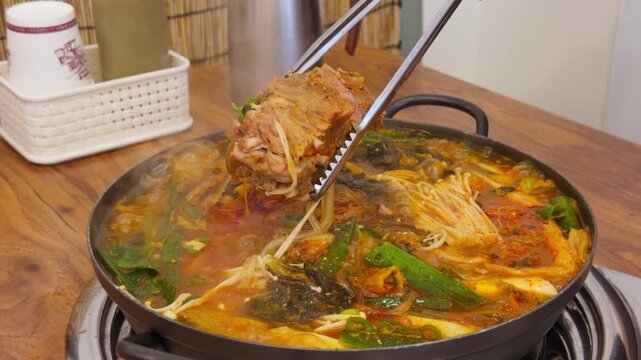 Korean Pork Spine Potato Soup Gamjatang Chopsticks Lifting Pork Bone Close-Up