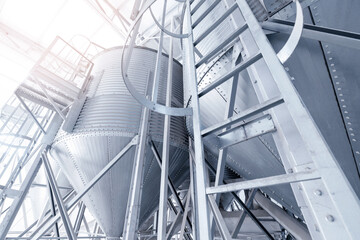 Fototapeta premium Modern industrial metal silos and ladders in agricultural facility
