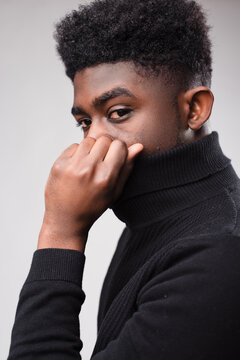 Young Black man with stylish haircut wearing a black turtleneck