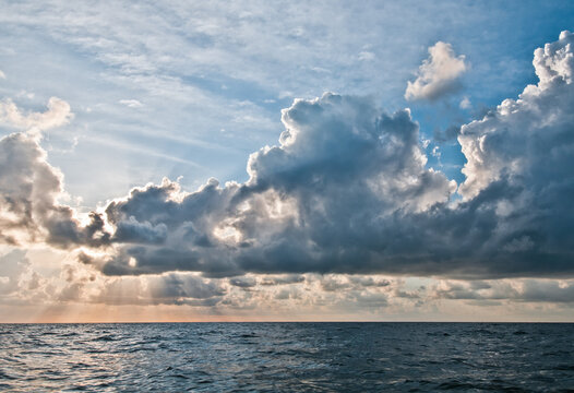 Dramatic sunbeams break through clouds over the ocean