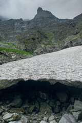 Dramatic mountain peak shrouded in mist above a snow cornice in © Cavan