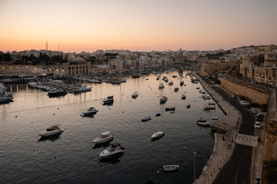 Historic Mediterranean harbor full of boats at dawn