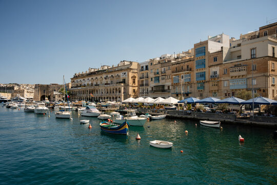 Boats docked along a sunny Maltese waterfront