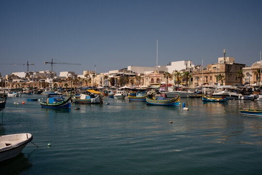Traditional Maltese luzzu boats in a sunny harbor