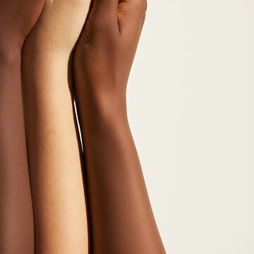 Close up of three diverse arms with different skin tones side by side in studio, multiracial foundation shades matching, inclusive beauty and DEI unity concept with large copy space