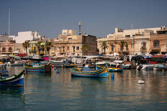 Traditional Maltese luzzu boats in a sunny harbor