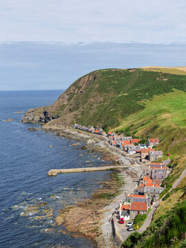 The Old Fishing Village of Crovie with its distinctive stone pier or Breakwater jutting out into the Moray Firth from the rocky shoreline.