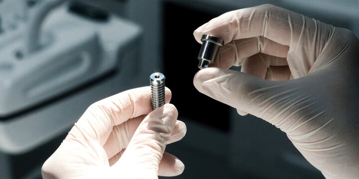 Dental clinic implants consultation concept. A gloved person assembling a small mechanical part, highlighting precision and careful handling in a controlled environment.