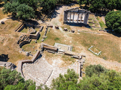 Apollonia Archaeological Park in Albania. Aerial drone view of ancient archaeological ruins with a preserved classical structure, stone foundations and amphitheater in a dry Mediterranean landscape.