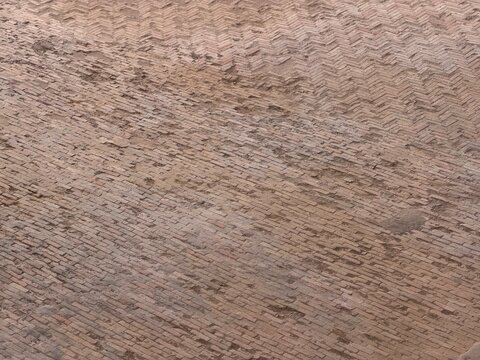 Weathered brick paving showing herringbone pattern background
