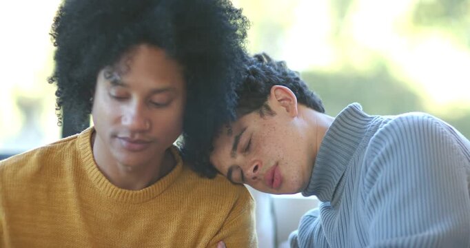 African American men sitting on couch by window, mustard sweater letting tired man rest head