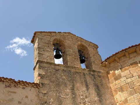 Old stone church bell tower against blue sky