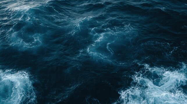 View of a deep blue ocean with foam swirls showing movement. Large space without any objects in sight.