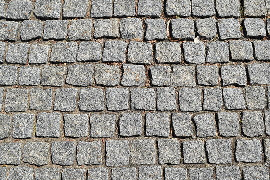 Weathered gray stone pavers in regular pattern, textured pavement background