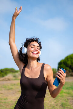 Woman enjoying music dancing with headphones outdoors