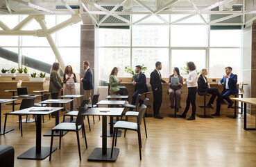 Obraz premium Business team colleagues people in meeting networking. Professionals by windows in an open office exchange ideas plan projects and maintain communication. Teamwork and collaboration idea now.