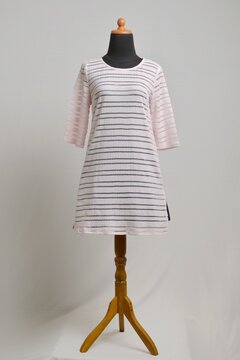 Soft pink sweater dress with sheer stripes on mannequin display