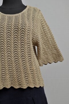 Cute milk brown crocheted blouse with navy mini skirt on a dress form