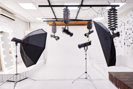 Professional Photo Studio Interior with Lighting Equipment and White Backdrop