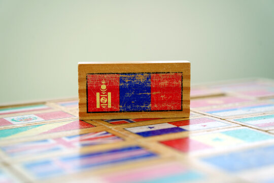 Wooden toy block with Mongolian flag on world flags background
