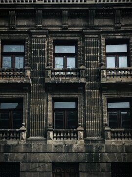Fachada de edificio hist&oacute;rico con balcones de piedra y ventanas antiguas