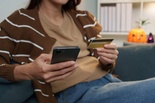 Cropped view of woman holding credit card and smartphone for online shopping payment
