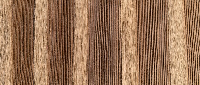 Abstract texture of harvested barley straw laid in vertical rows with warm brown tones