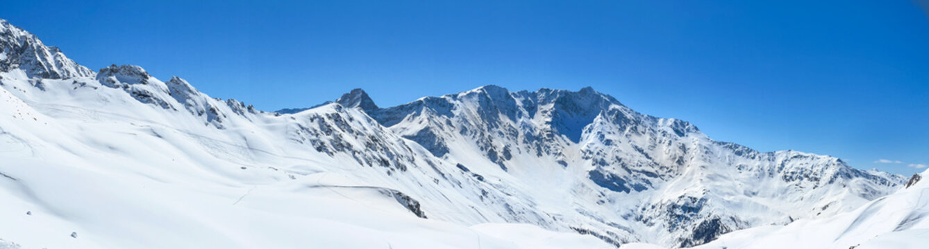 off-piste in the Tarentaise ski resort, the Bellecote massif. Snowy alpine mountain peak under blue sky